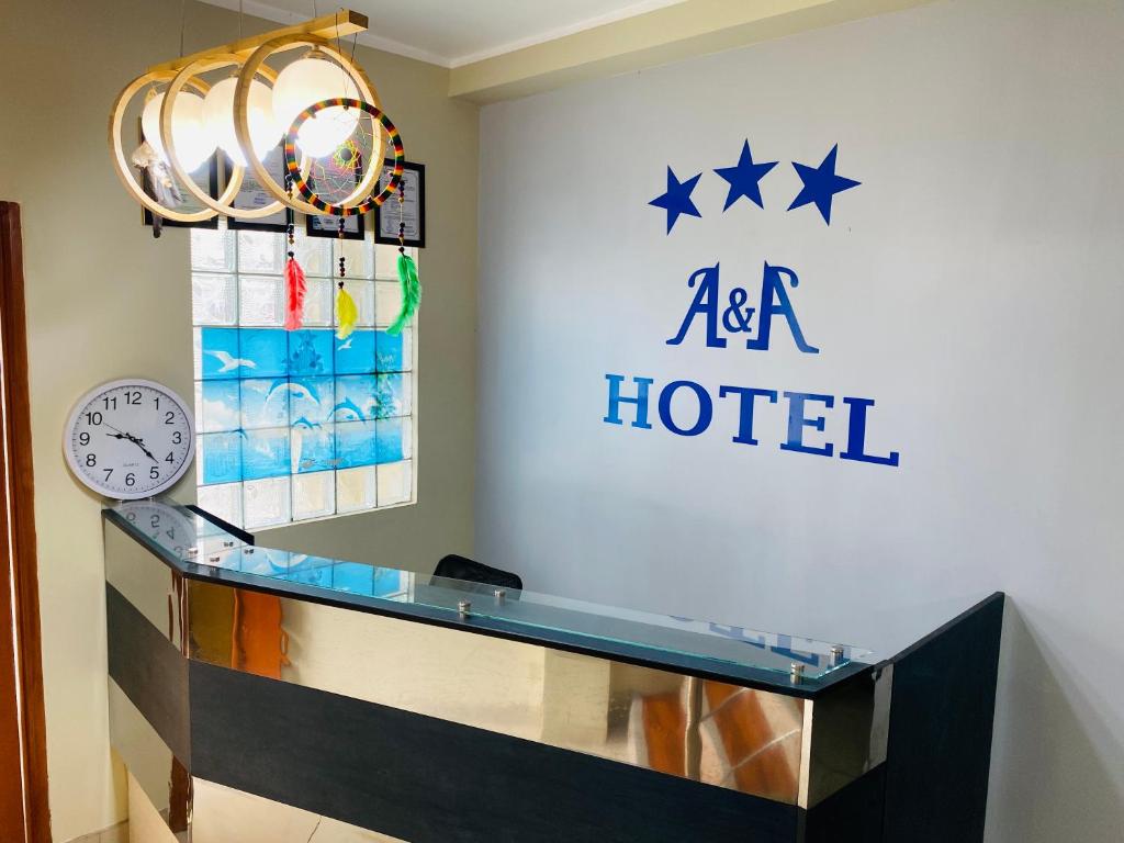 伊基托斯A&A HOTEL的酒店前台设有时钟和aaa酒店标志