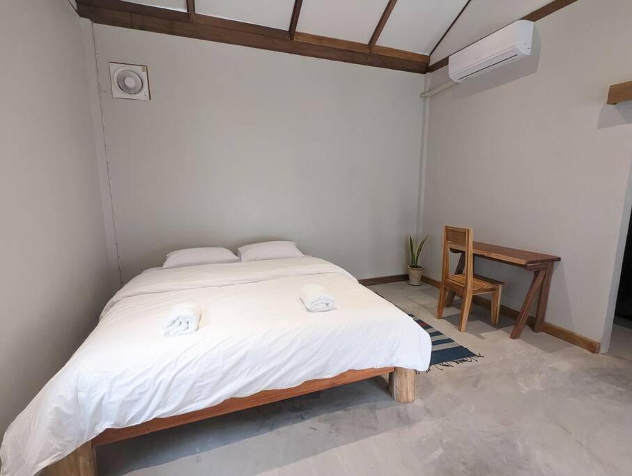 琅勃拉邦Maison moderne proche du centre-ville的卧室配有一张大白色的床和书桌