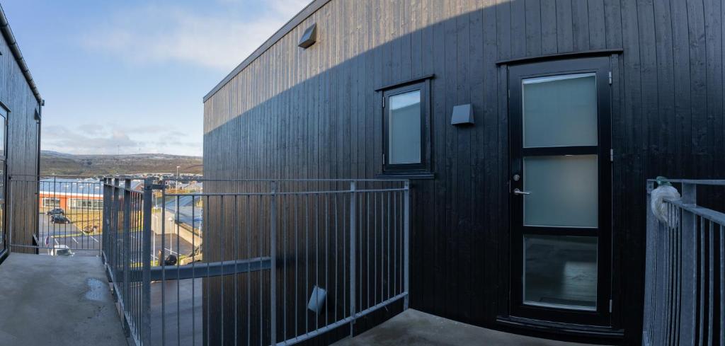 托尔斯港New 2 BR Apt - Ocean and Mountain View的黑色建筑,设有2扇窗户和阳台