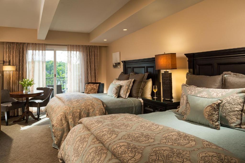 卡姆登16湾景旅馆的酒店客房设有两张床和一张桌子。
