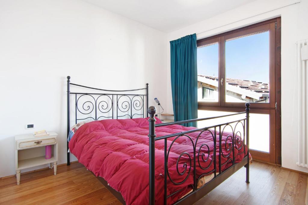 DorioCasa Leonardo的一间卧室配有一张带红色棉被的床和窗户。