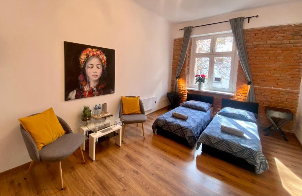 克拉科夫Topolove Rooms & Apartments的客厅配有一张床和一幅女画
