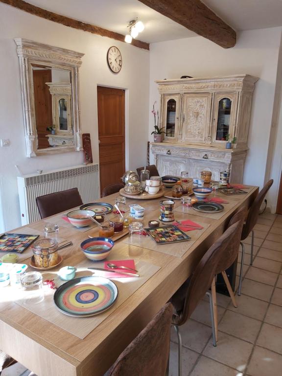 Roubion雷皮卡布拉民宿的一张大木桌,上面放有盘子和碗