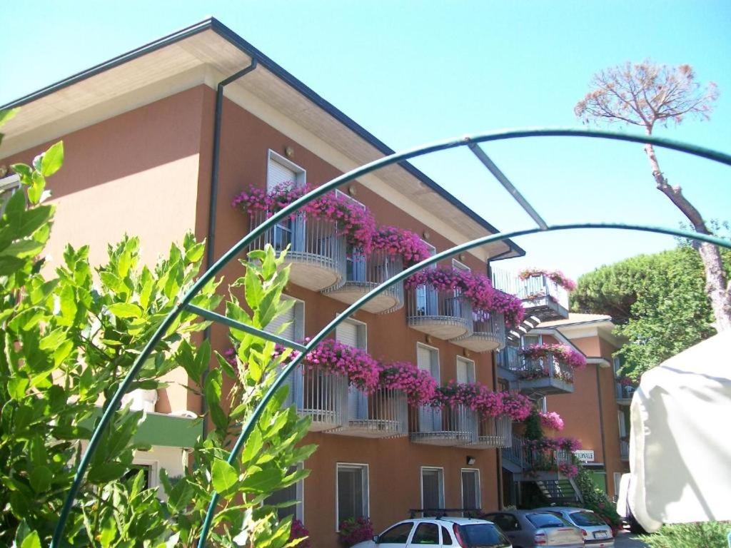 米兰马瑞提那Hotel Nazionale的阳台上布满紫色花的建筑