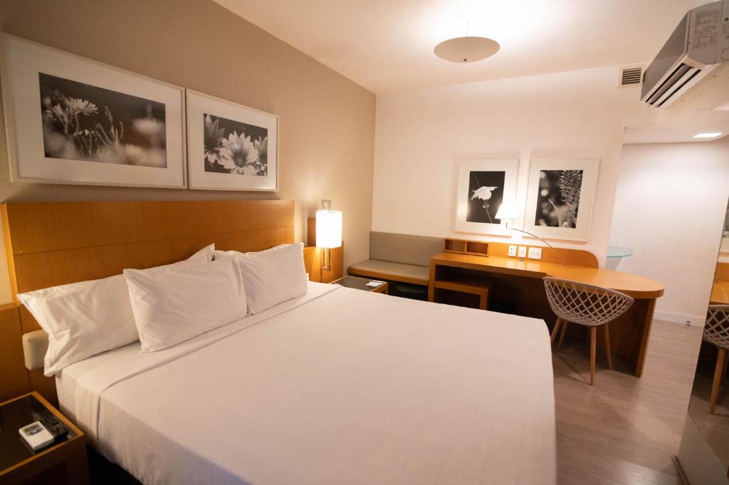 贝洛奥里藏特H2 Platinum Lourdes的配有一张床和一张书桌的酒店客房