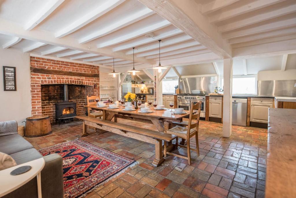 黑尔斯沃思Ivy House Mells的厨房配有木桌和壁炉。