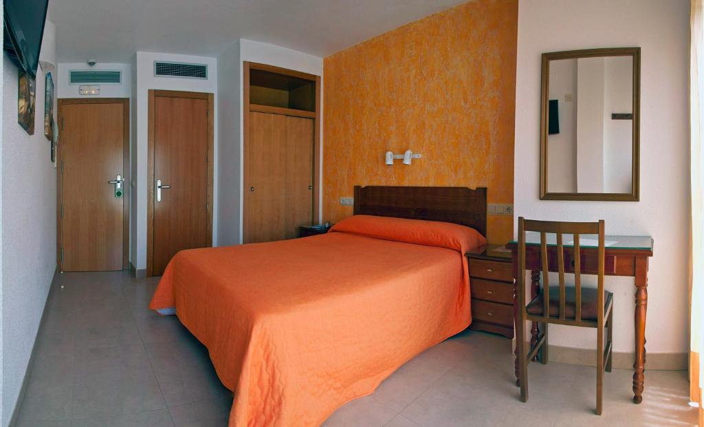 佩尼斯科拉马里纳酒店的一间卧室配有一张床、一张书桌和一面镜子