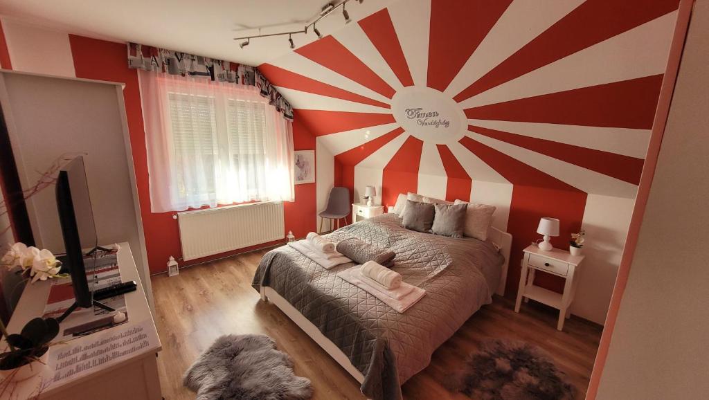 ZalaszabarTímea Vendégház Zalaszabar的卧室设有红色和白色条纹的大墙