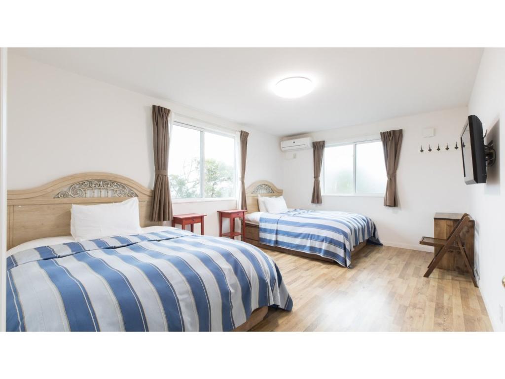 立山町TEA TREES - Vacation STAY 86532v的一间卧室设有两张床和两个窗户。