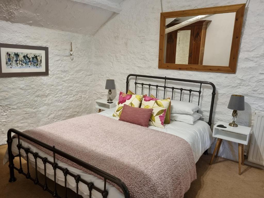 卡姆尔福德Mayrose Cottage, Charming Cornish Cottage for the perfect escape...的卧室配有一张床,墙上设有镜子