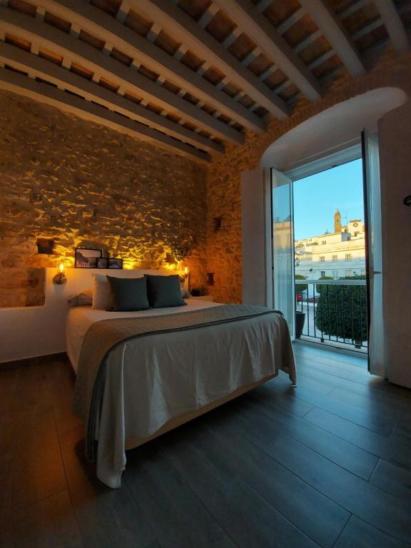 麦地那西多尼亚Alojamientos Plaza de España的一间卧室设有一张床和砖墙