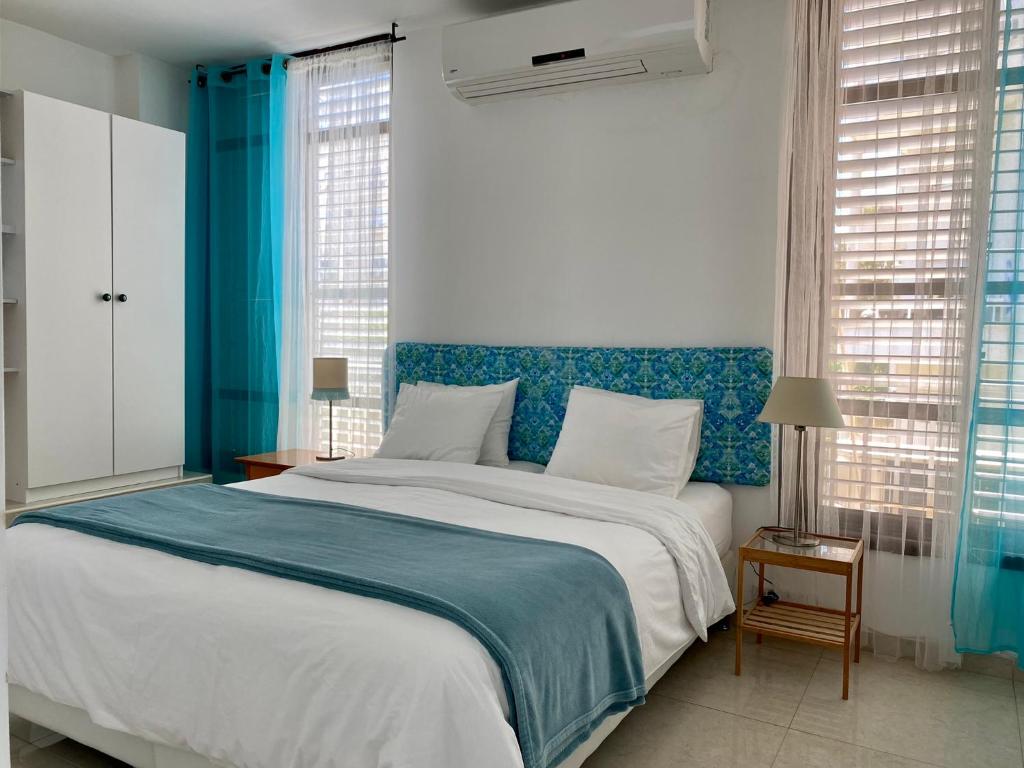 内坦亚Sea You Soon!的一间卧室配有一张大床和蓝色床头板