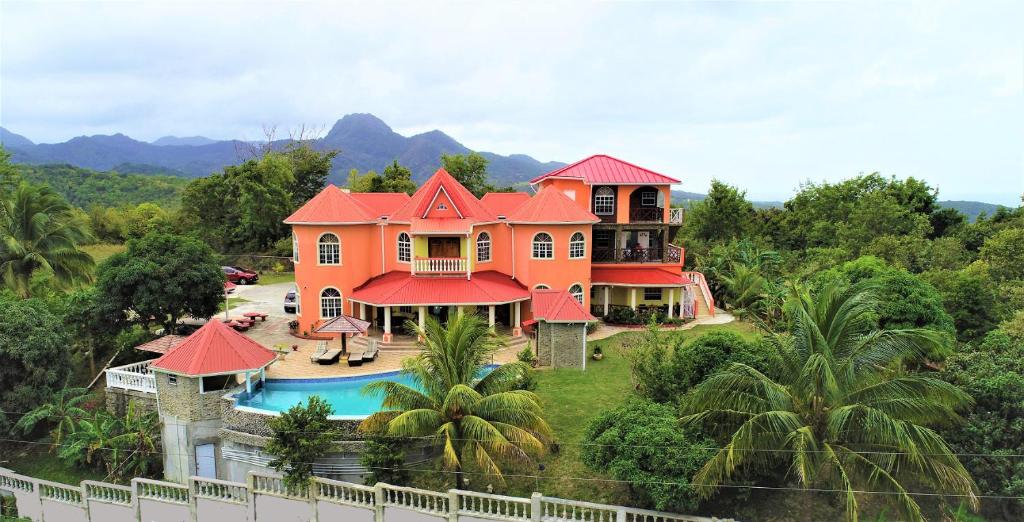 昂斯拉雷区Eden Crest Villa的一座大型橙色房子,前面设有一个游泳池