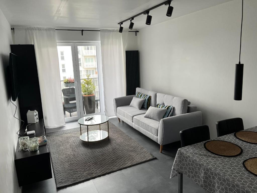 卡托维兹Apartament Bażantów 26的客厅配有沙发和桌子