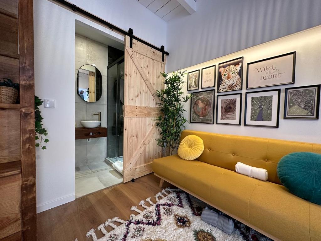 埃斯托利尔Estoril Tiny Home 5 Minutes From the Beach的客厅设有黄色沙发和推拉谷仓门。