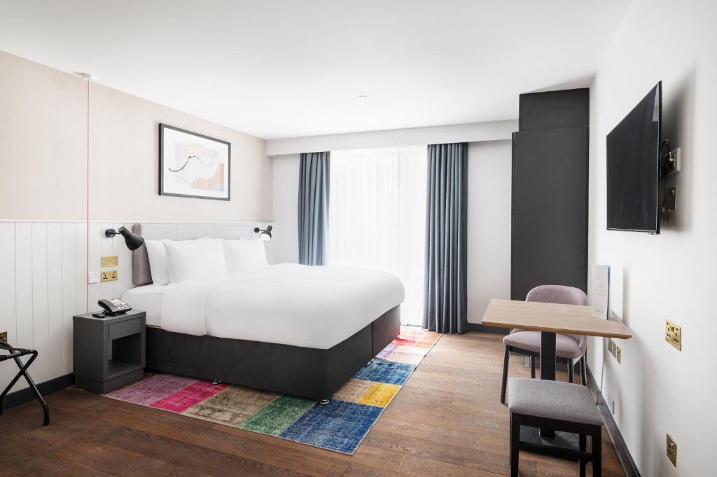 布莱顿霍夫Staybridge Suites Brighton, an IHG Hotel的酒店客房配有一张床铺和一张桌子。