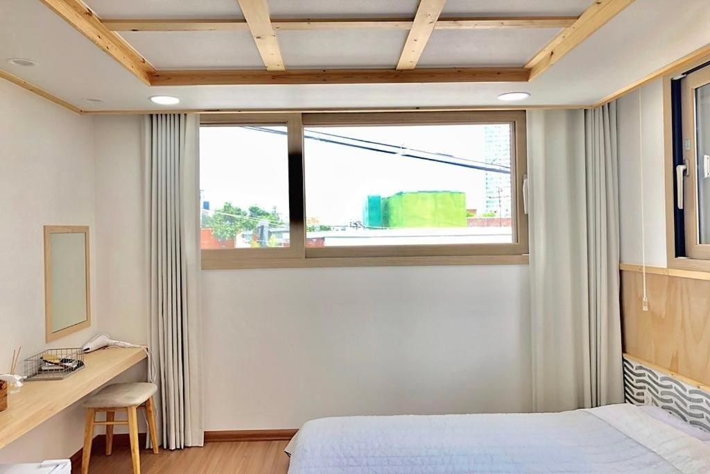 木浦市Cheukhu-dong 19street Guesthouse的一间卧室配有一张床、一张书桌和一个窗户。