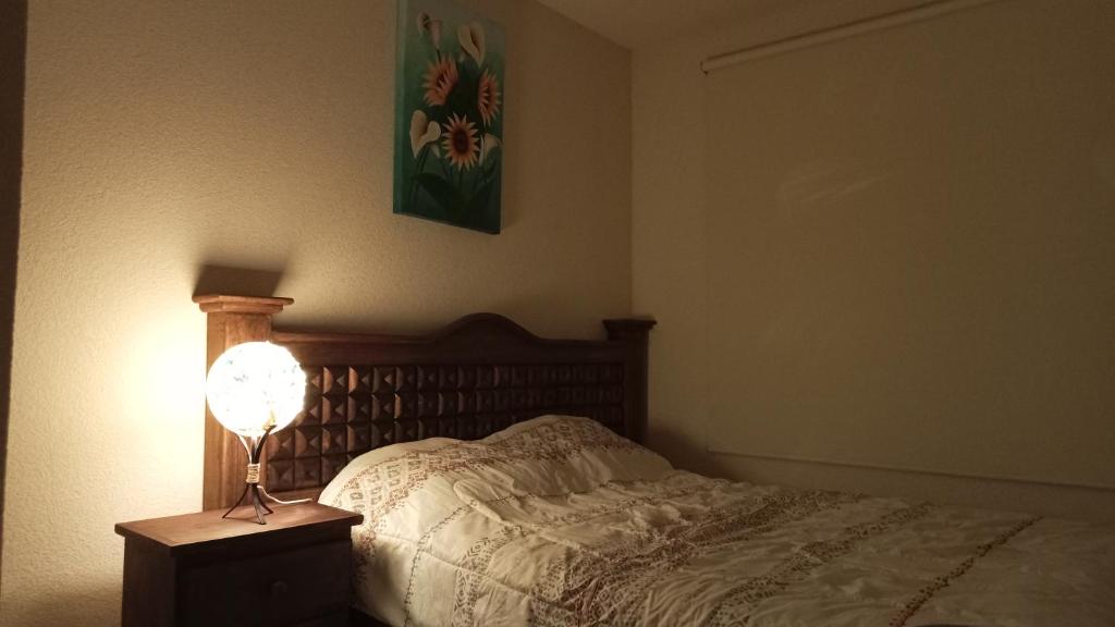 TlayecacConfortable casa de descanso para fin de semana的一间卧室,配有一张带台灯的床头柜