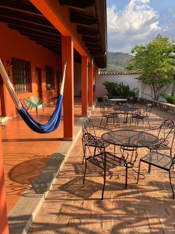 科潘玛雅遗址La Casa de Cafe Bed and Breakfast的一个带桌椅和吊床的庭院