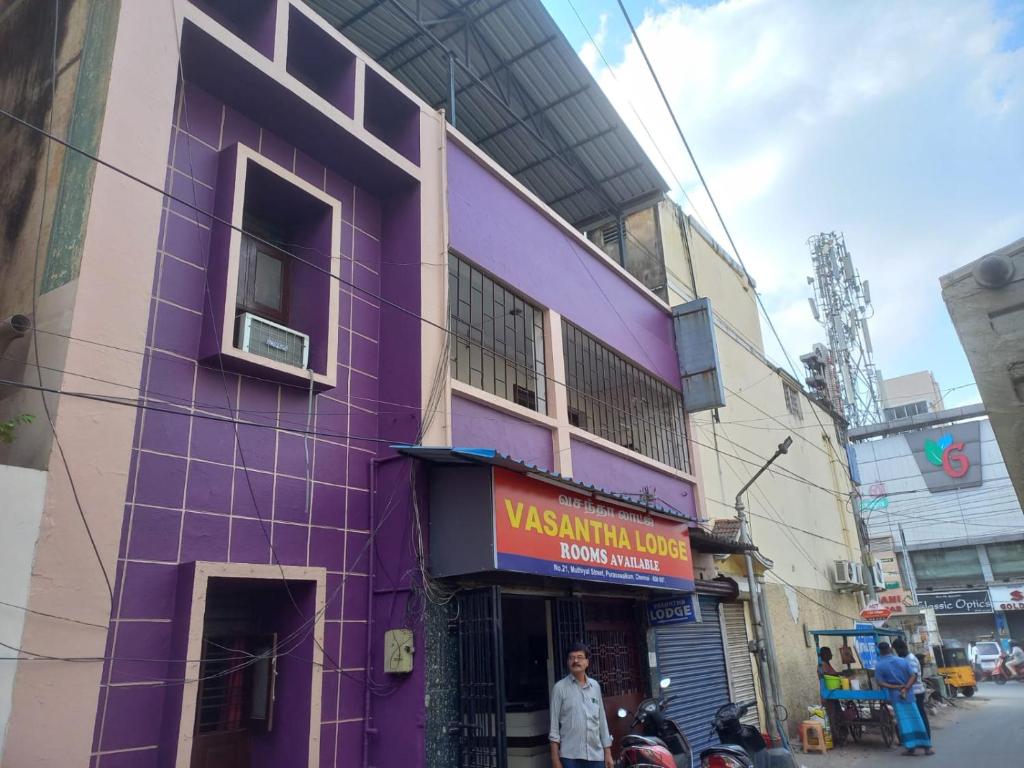 钦奈Vasantha Lodge Purasawalkam chennai的街道边的紫色建筑