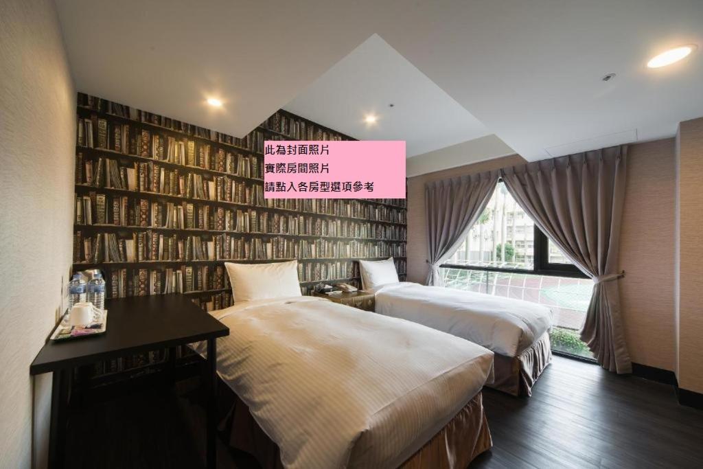 台北趣旅馆．林森馆的一间卧室设有两张床和一堵书墙