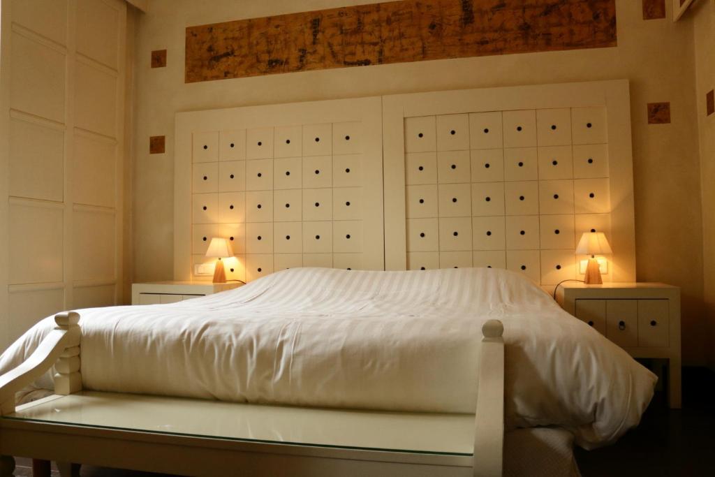 比奇乐斯特拉斯堡酒店及餐厅的卧室配有带两盏灯的白色床