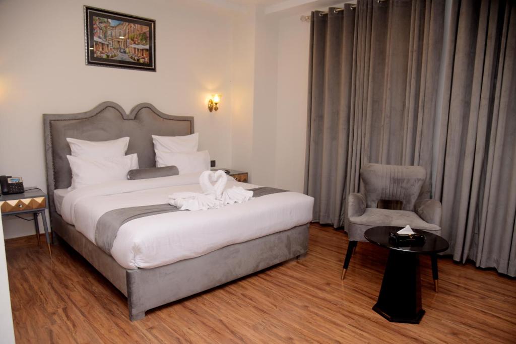 拉合尔The Rich Hotel & Apartments的一间卧室配有一张大床和一把椅子
