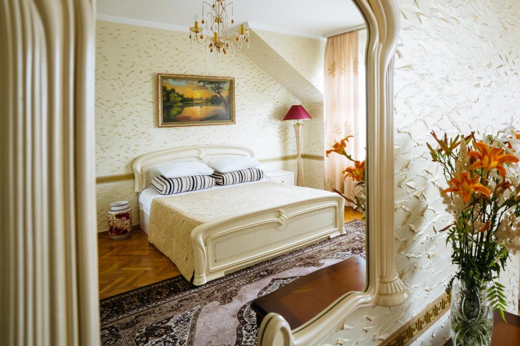基希讷乌ezio的卧室配有白色的床和镜子