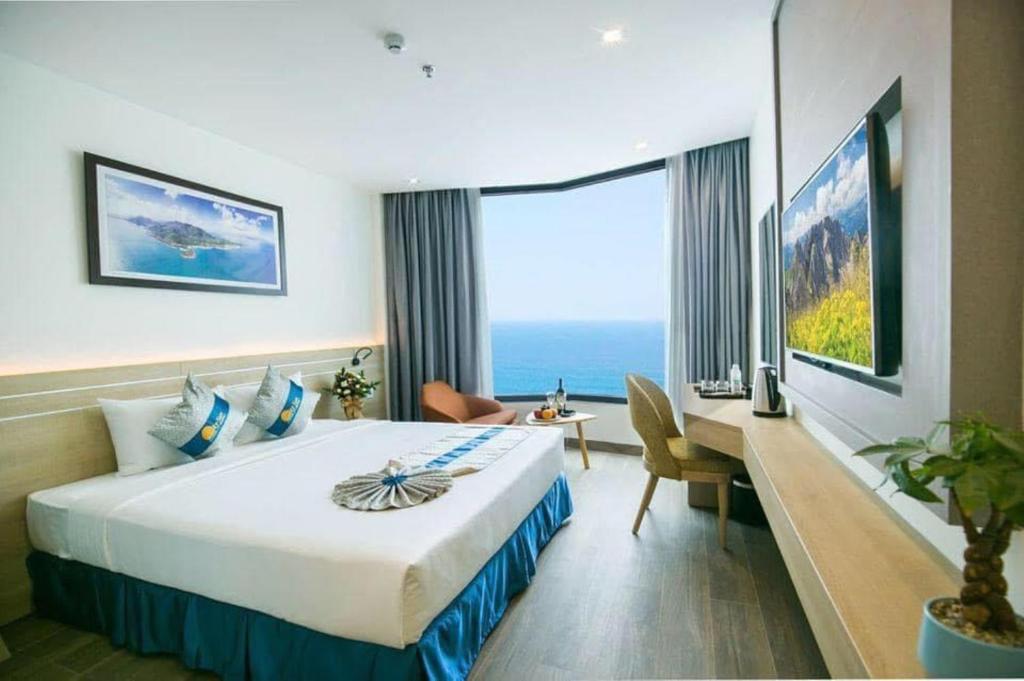 芽庄Lucky Sun Hotel的酒店客房设有一张大床和一张书桌。