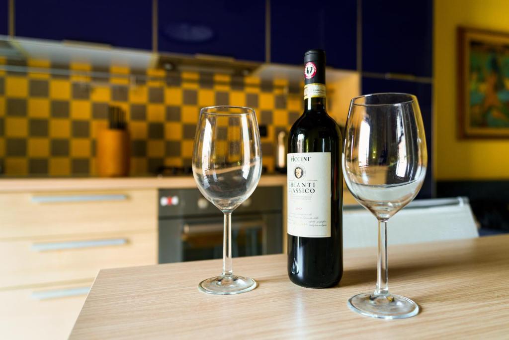 锡耶纳19 Lodge的桌子上放有一瓶葡萄酒和两杯酒