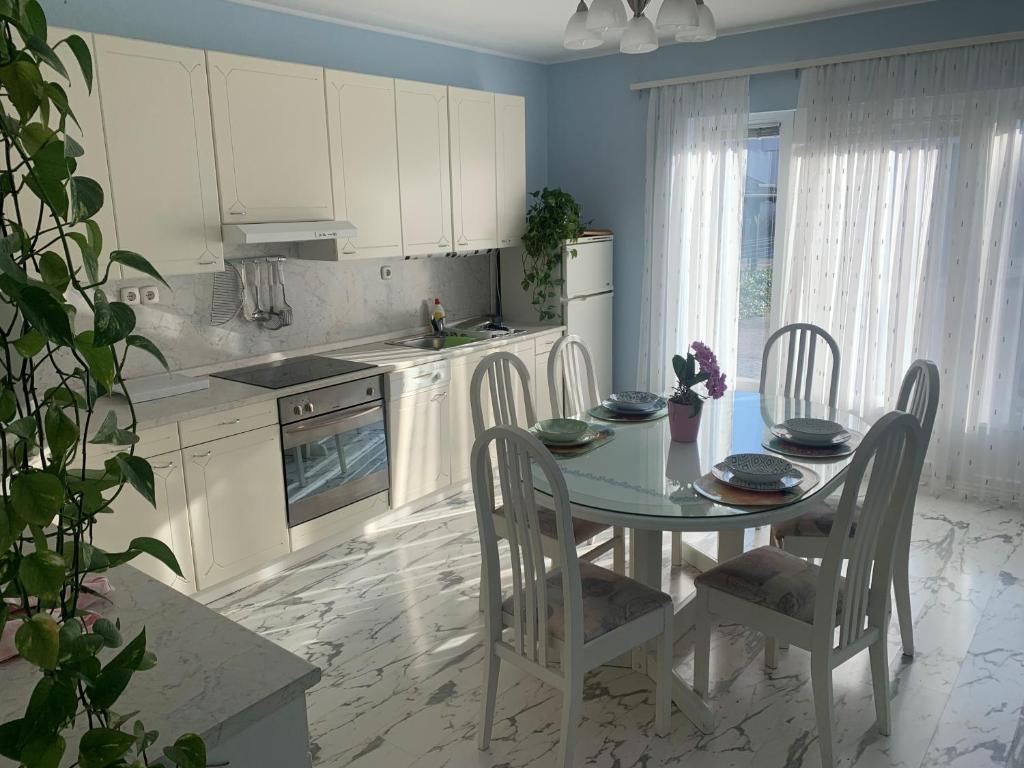 马里博尔Sweet Home Apartment的一间带桌椅的厨房和一间带白色橱柜的厨房