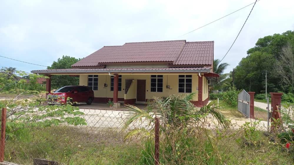 Kampong Wakaf TengahMufeed Homestay的前面有一辆红色汽车的小房子