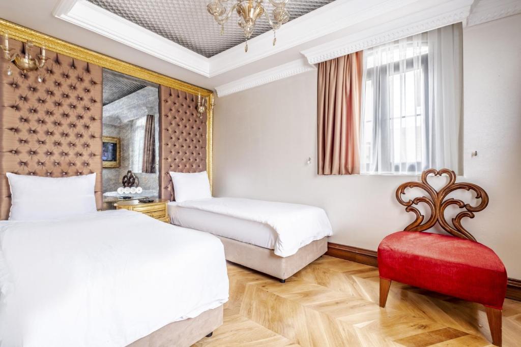 伊斯坦布尔Glamorous Authentic Studio in Üsküdar的一间卧室配有两张床和红色椅子