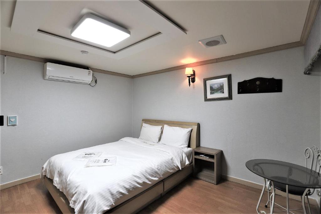 大田Hani Motel的一间卧室配有一张床、一张桌子和一个窗户。