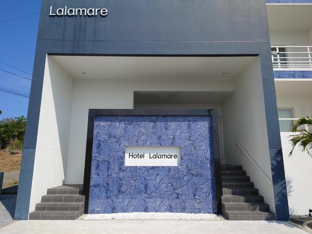 今归仁村Lalamare Kouri的一座建筑,上面有蓝色的门,上面有标志