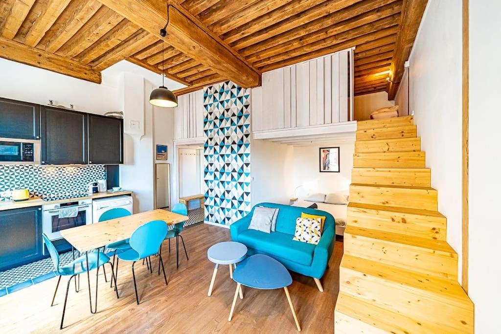 里昂Superb 1 bedroom apartment - Croix Rousse district的厨房以及带蓝色沙发和桌子的客厅。