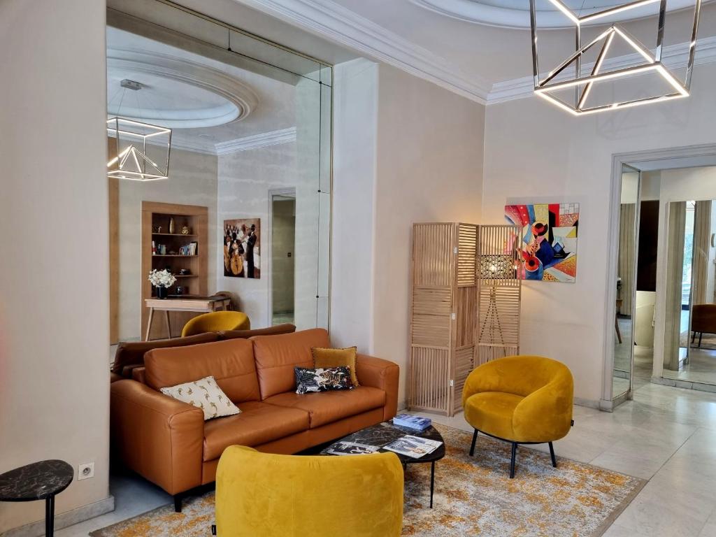 尼斯尼斯卡尔顿酒店的客厅配有棕色沙发和黄色椅子