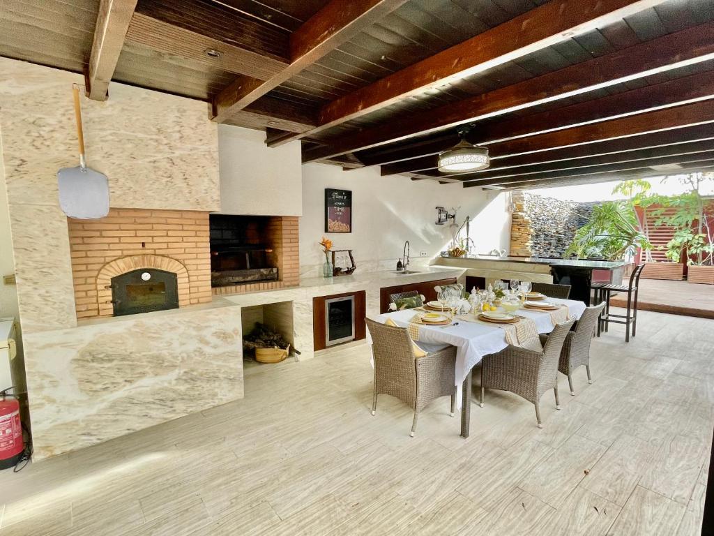 阿利坎特Chalet exclusivo bonalba的厨房以及带桌子和壁炉的用餐室。