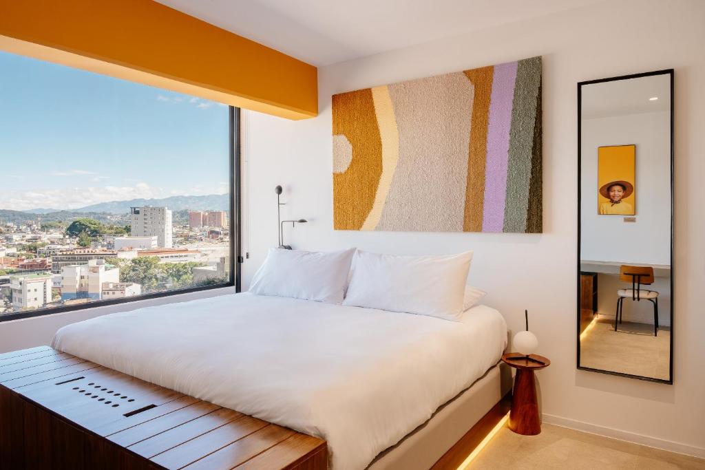 危地马拉Good Hotel Guatemala City的一间卧室设有一张大床和一个大窗户