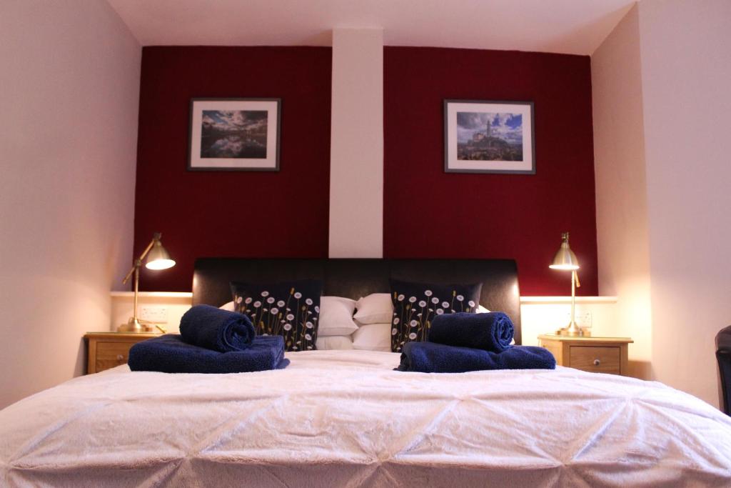 哈罗盖特Acomb Lodge的一间卧室配有一张大床和蓝色枕头