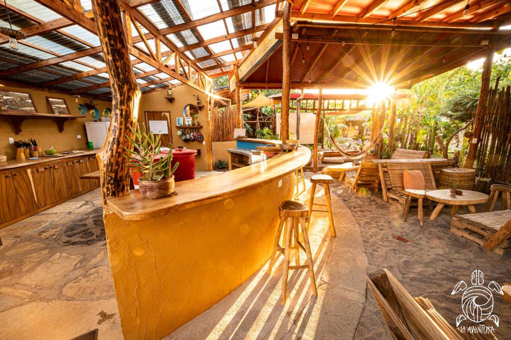 波波约Casa La Aventura Guasacate - Popoyo的餐厅内的酒吧配有桌椅
