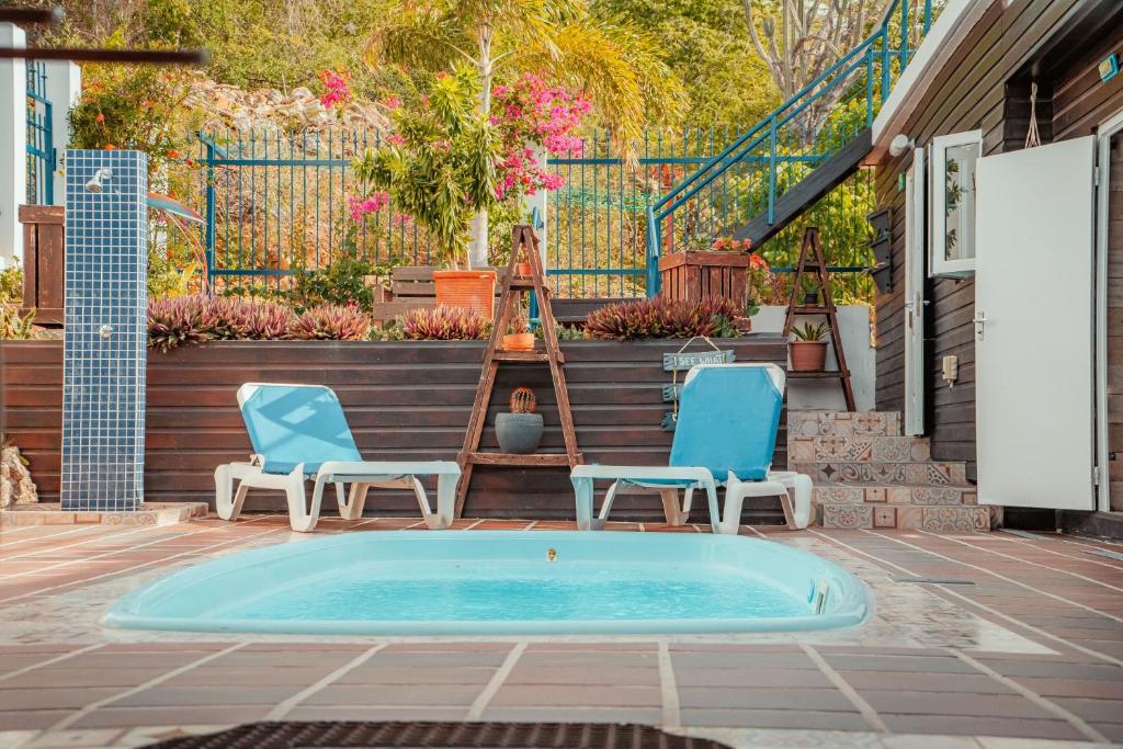 威廉斯塔德Westpunt Beach Apartments的一个带两把椅子的庭院和一个游泳池