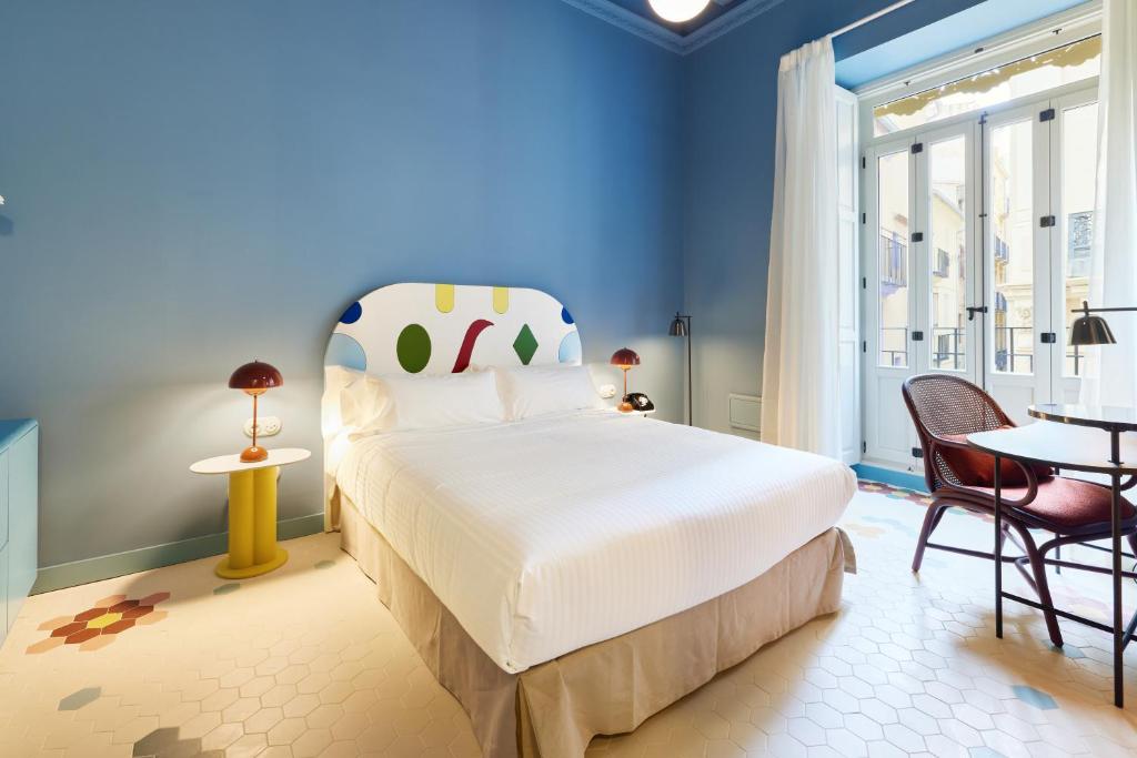 瓦伦西亚Casa Clarita的卧室配有一张床和一张桌子及椅子