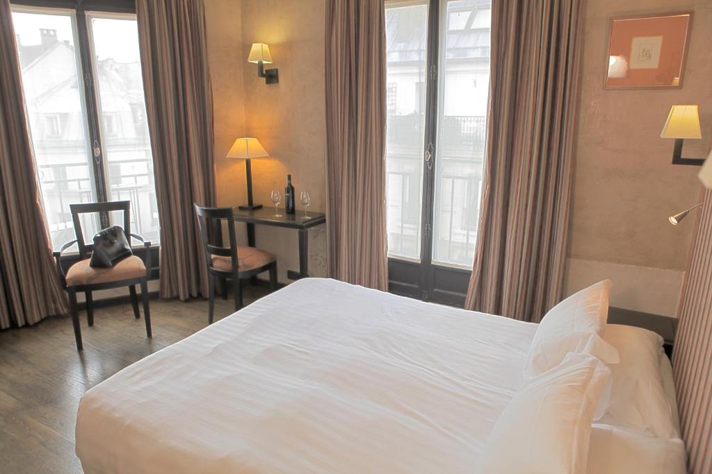 巴黎欧洲圣赛维林巴黎酒店的酒店客房设有一张床、一张书桌和窗户。