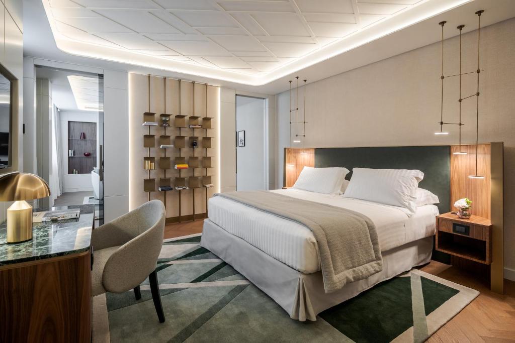 米兰Casa Baglioni Milan - The Leading Hotels of the World的一间卧室配有一张大床和一张书桌