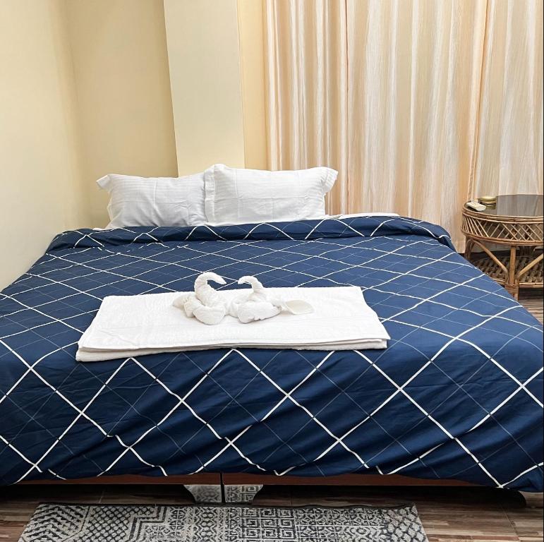 因帕尔Iranyai Homestay的一张蓝色的床,上面有两条白色的毛巾