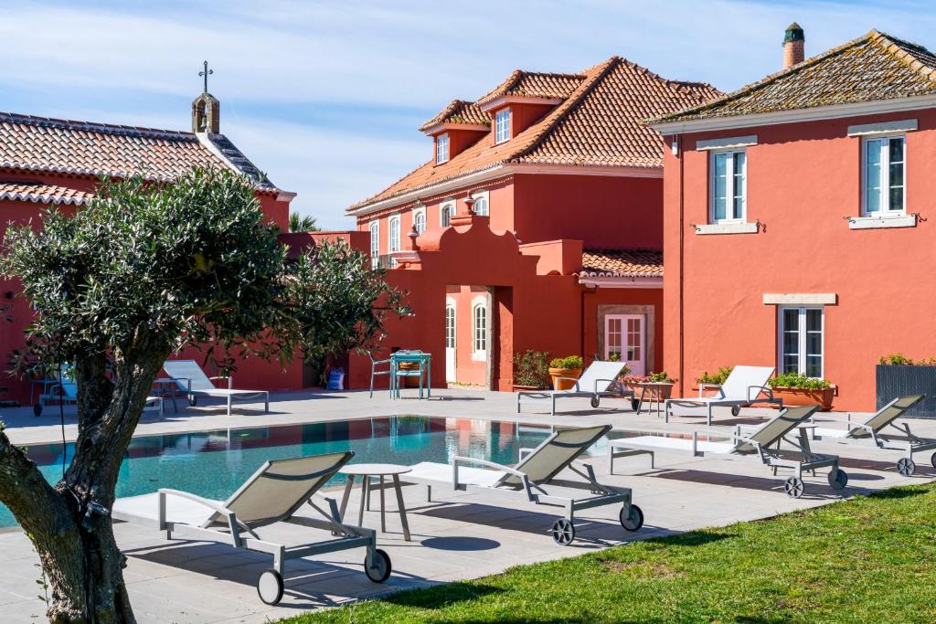 辛特拉帕克比斯博精品旅馆的房屋前设有带椅子的庭院和游泳池