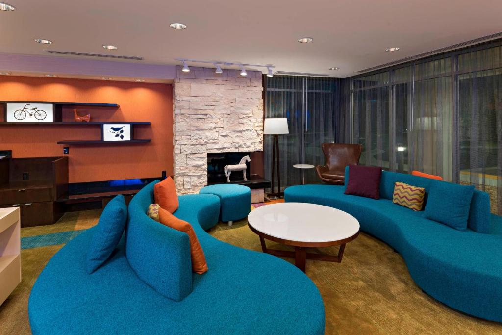 都柏林Fairfield Inn & Suites by Marriott Dublin的客厅配有蓝色的家具和壁炉