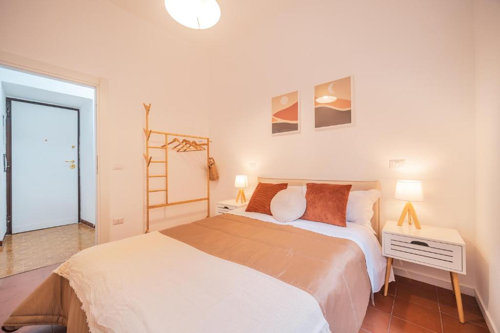 罗马Gazometro Rome - Holiday House的一间卧室配有一张床、一张桌子和两盏灯。