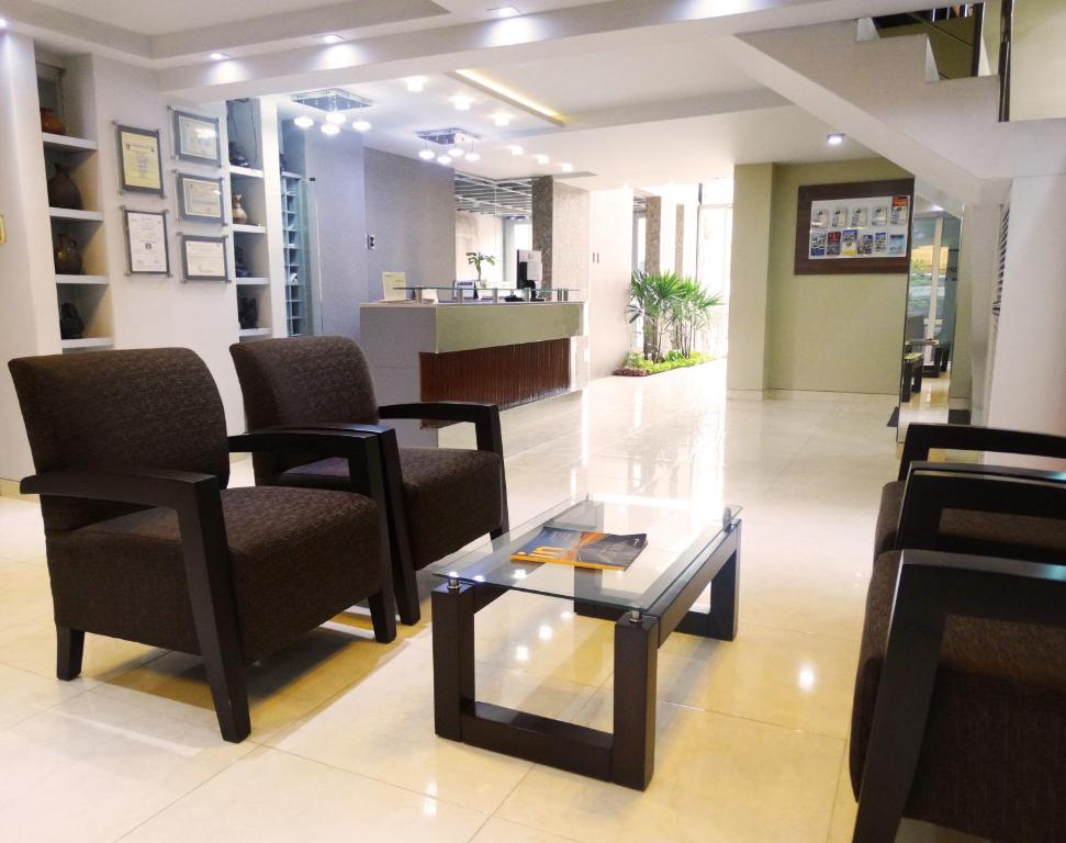 齐克拉约Hotel Gran Sipan的一间设有椅子和茶几的等候室